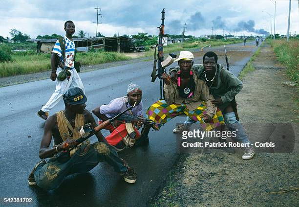 Armed rebel fighters of the NPFL pose on a road in Monrovia during the Liberian Civil War. In 1989, Charles Taylor, leader of the NPFL , launched a...