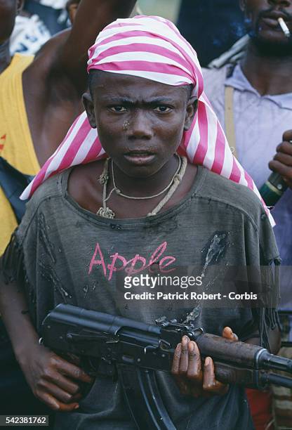 Young NPFL rebel brandishes an assault rifle in Monrovia during the Liberian Civil War. In 1989, Charles Taylor, leader of the NPFL , launched a...