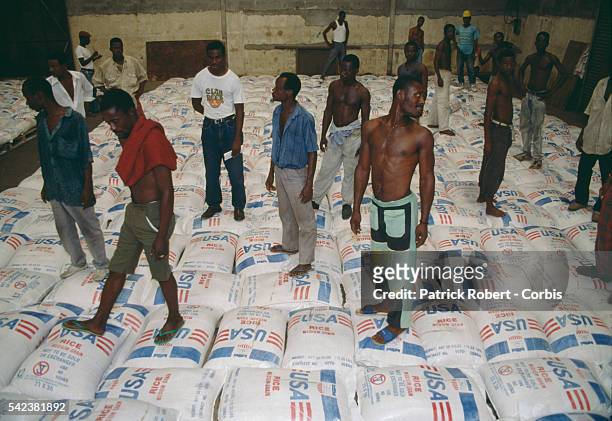 Men unload and store sacks of United Nations foodstuffs for people caught up in the communal conflict of the Liberian Civil War. In 1989, Charles...