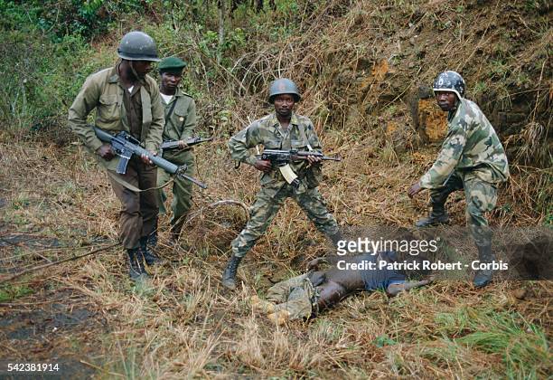Soldiers stand over the body of a young man killed during the Liberian Civil War. AFL forces under pressure from Ghanaian ECOMOG forces are defending...