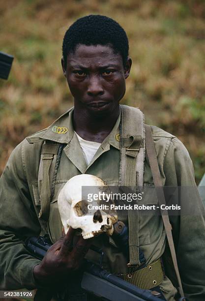 An AFL soldier holds the skull of a person killed during the Liberian Civil War. AFL forces under pressure from Ghanaian ECOMOG forces are defending...