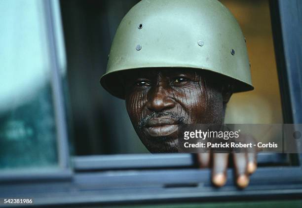 An AFL soldier with tribal facial scars looks through a window in Schieffelin during the Liberian Civil War. AFL forces under pressure from Ghanaian...