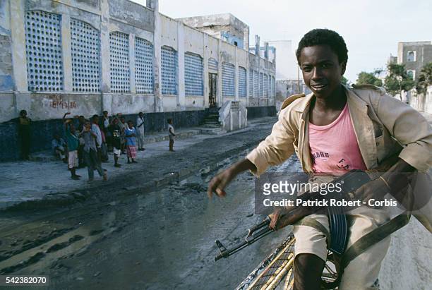 Somali boy carries a machine gun along a street in Mogadishu before the arrival of 28,000 United States Marines, sent during Operation Restore Hope...