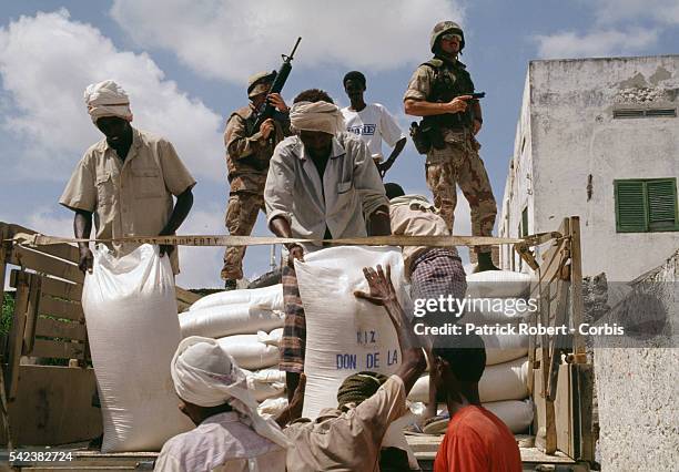 Relief workers distribute the first military convoy of humanitarian aid in Mogadishu after 28,000 United States Marines were sent during Operation...
