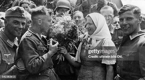 Germany's invasion of the Soviet Union : German soldiers receive a warm welcome by locals after entering an Ukrainian village- photographer: Hoffmann