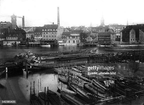 Kleine und grosse Lastkähne aus Holz liegen an einer Anlegestelle am südlichen Spreeufer. Gegenüber die der Spree zugewandten Häuser der Stralauer...