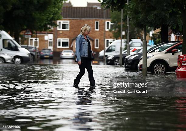 Woman steps through water as she crosses a flooded street on June 23, 2016 in Battersea, London, England. Parts of the capital and the South East...