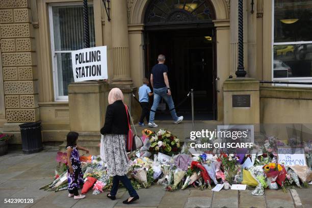 People pass floral tributes to murdered MP Jo Cox outside Batley Town Hall as they arrive to vote in the EU referendum in Batley, northern England on...