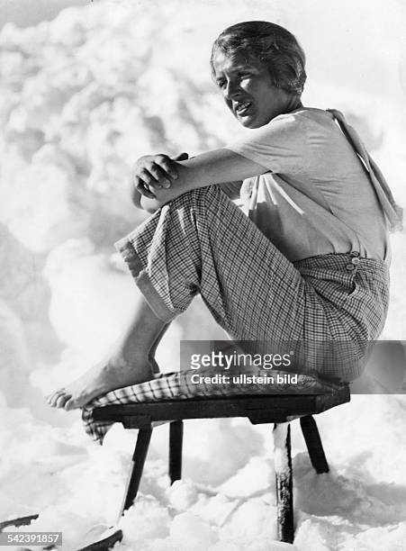 Winter pictures Young woman sitting barefoot on a stool in the snow - 1937 - Photographer: Wolff & Tritschler - Published by: 'B.Z.' 20.1/1937...