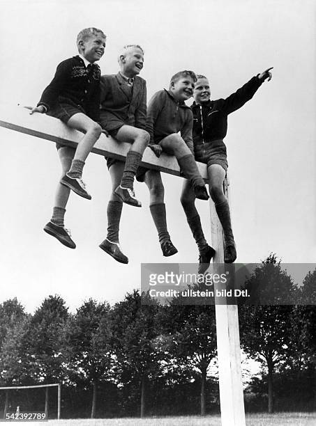 Jungen sitzen auf der Latte eines Fussballtores- 1955