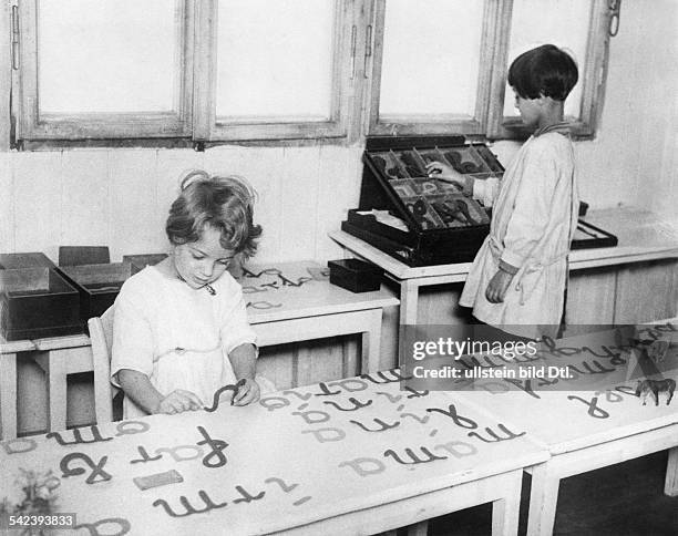 Montessori - Schule in Berlin: Schreiben und Lesen werden gleichzeitig beim Bildspiel durch das Aneinanderfügen der richtigen Buchstaben gelernt-...