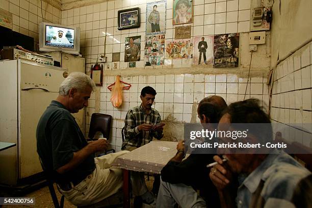 Everywhere in Iraq, television sets are tuned into the Arab-language station Al Jazeera or other Arabic channels, like in this cafe where locals play...