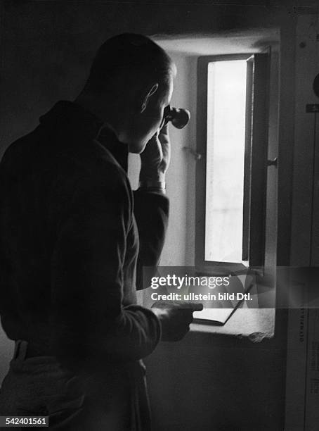 Olympische Spiele 1936 in Berlin- Beobachter mit Fernglas und Stoppuhr im Anzeige-Turm. Er uebermittelt erste Nachrichten, die wichtige...