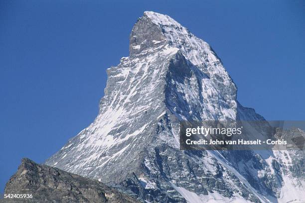 View of the rock face and partially snow-covered Mount Cervin .