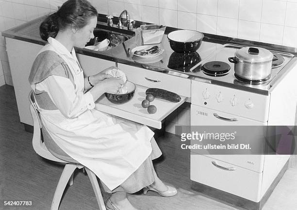 Junge Frau beim Gemüseputzen vor einer AEG - Küchenkombination, bestehend aus Elektroherd, Arbeitstisch und Spüle mit eingebautem...
