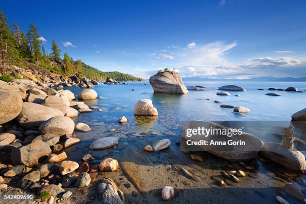 long exposure of nevada side of lake tahoe by bonsai rock, a popular tourist destination, on summer evening - lake tahoe fotografías e imágenes de stock