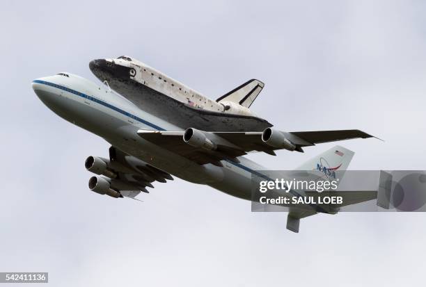 The Space Shuttle Discovery, aboard a specially modified NASA Boeing 747, flies over the Washington, DC, April 17 as seen from Arlington, Virginia....