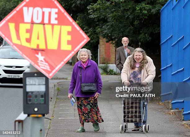 People walk past a "Vote Leave" sign as they arrive to cast their ballots at a polling station in Belfast, Northern Ireland, on June 23 as the United...