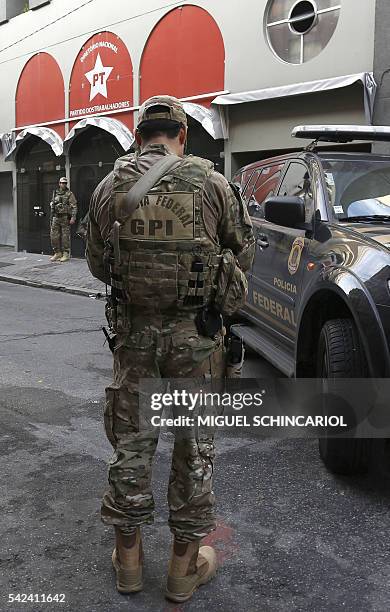 Brazilian Federal Police personnel keep watch in front of the national headquarters of the Worker's Party in Sao Paulo, Brazil on June 23, 2016. On...