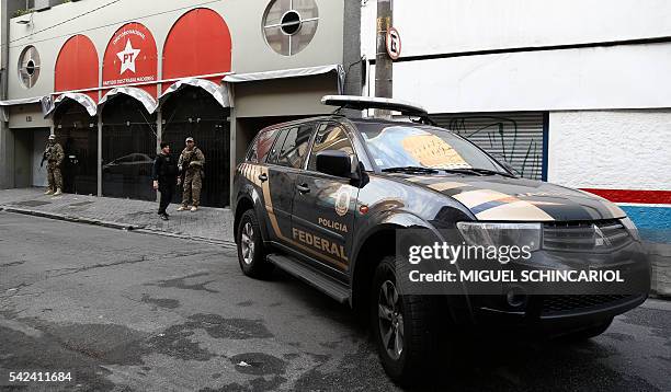 Brazilian Federal Police personnel keep watch in front of the national headquarters of the Worker's Party in Sao Paulo, Brazil on June 23, 2016. On...