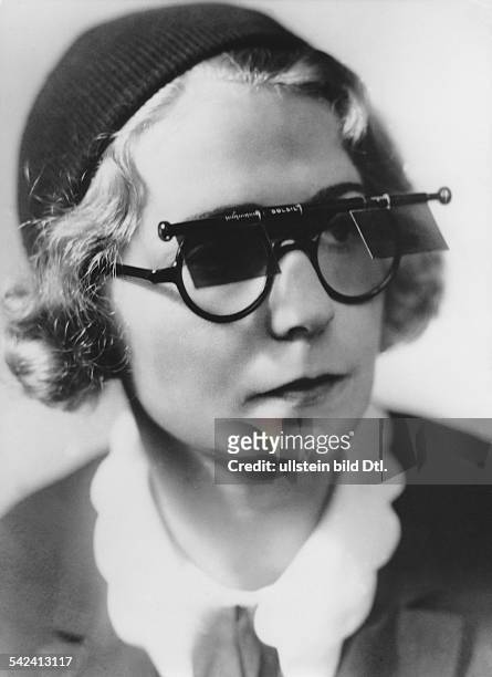 Woman with horn-rimmed glasses which can be altered into sunglasses- Photographer: Elli Marcus- 1931Vintage property of ullstein bild