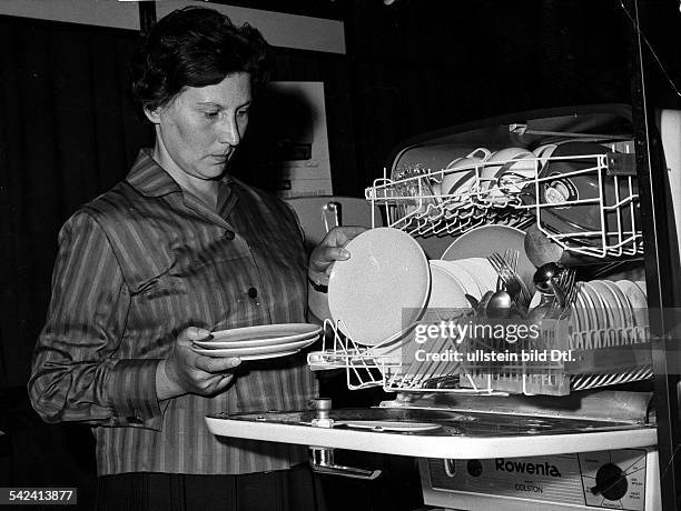 Hausfrau räumt Spülmaschine der MarkeRowenta ein- 1963