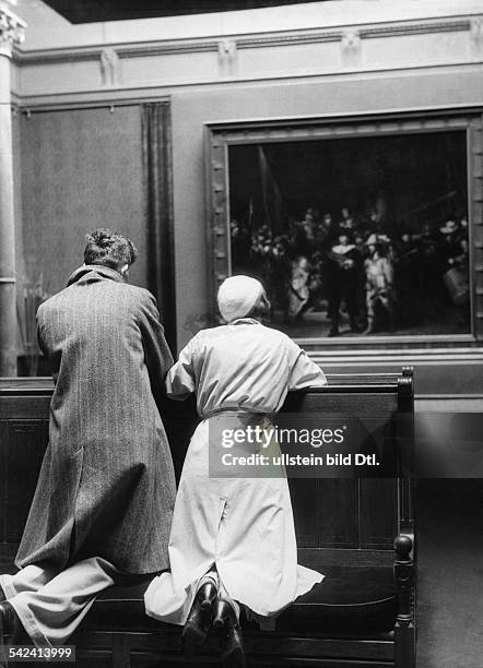 Netherlands Amsterdam : Kneeling visitors in the Rijksmuseum Amsterdam looking at Rembrandt's painting De Nachtwacht - 1933 - Photographer: Alfred...