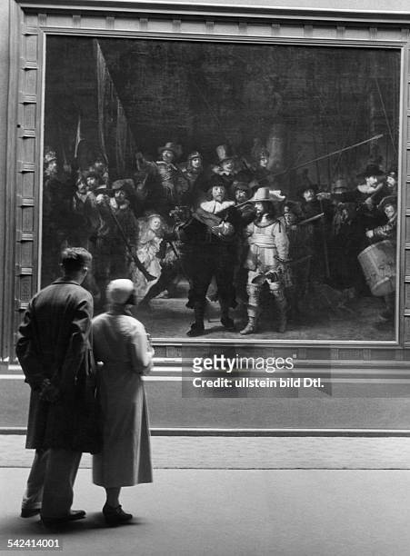 Netherlands Amsterdam : Visitors looking at Rembrandt's painting De Nachtwacht in the Rijksmuseum Amsterdam - 1933 - Photographer: Alfred Eisenstaedt...