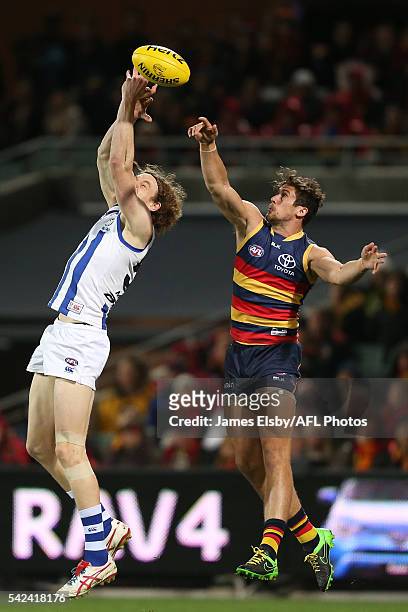 Ben Brown of the Kangaroos competes with Kyle Hartigan of the Crows during the 2016 AFL Round 14 match between the Adelaide Crows and the North...