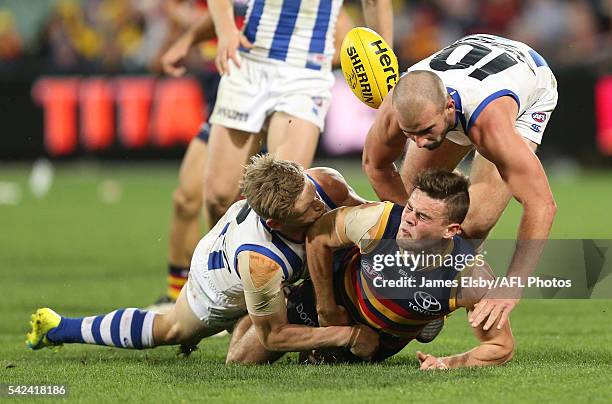 Jack Ziebell and Ben Cunnington of the Kangaroos tackle Brad Crouch of the Crows during the 2016 AFL Round 14 match between the Adelaide Crows and...