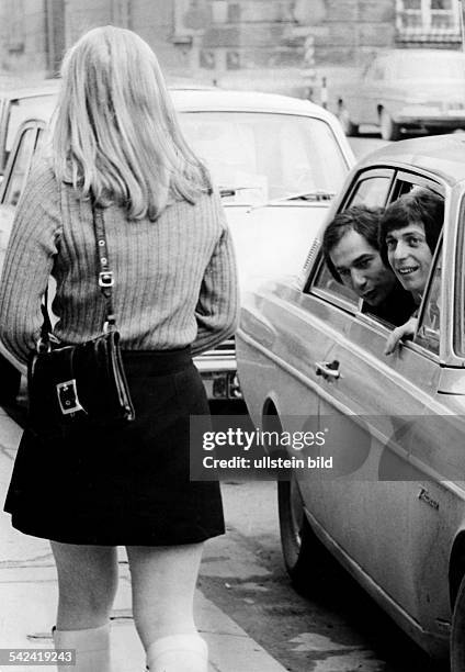 Mädchen im Mini-Rock wird von jungen Männern aus dem Auto heraus angesprochen.1971
