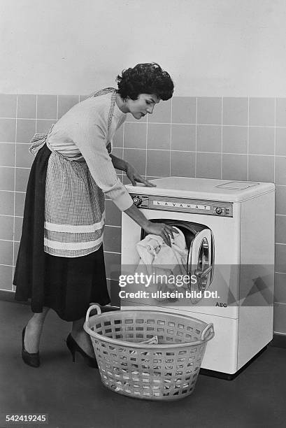 Junge Frau belädt Waschmaschine 'Lavamat`von AEG- 1958