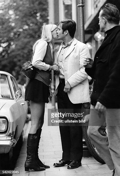 Pärchen bei der Begrüßung bzw. Abschied; sie trägt Minirock und Stiefel1969