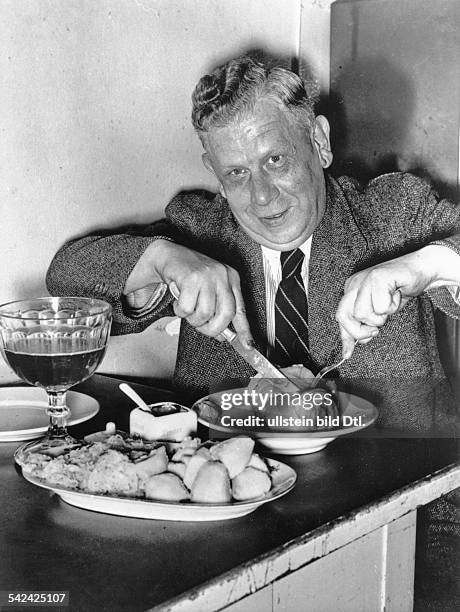 Germany, Berlin dishes: man eating a Eisbein with sauerkraut and drinking beer - Photographer: Herbert Hoffmann- Published in 12 Uhr Vintage property...