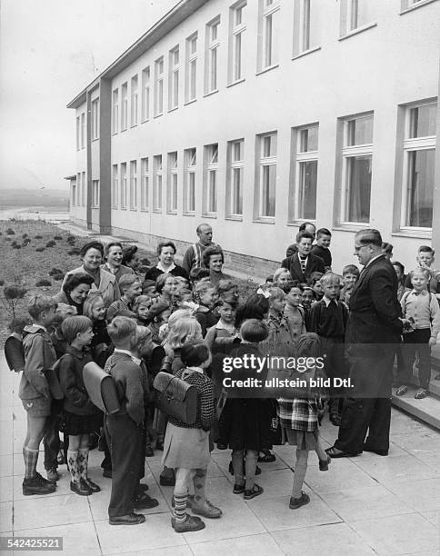 Die ersten Schüler der neuerbauten Grundschule am Bruno-Taut-Ring in Berlin Britz werden vom Lehrer begrüsst- April 1957
