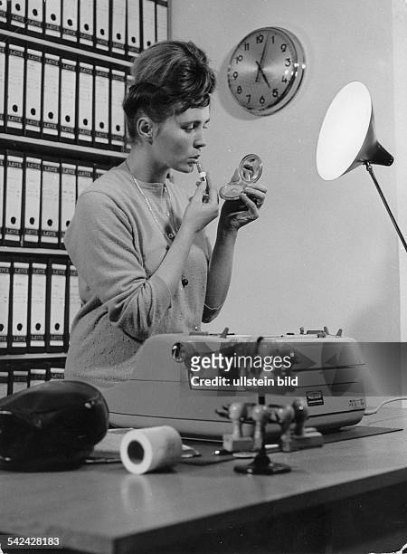 Sekretärin legt nach Dienstschluß im Büroneuen Lippenstift auf- 1968