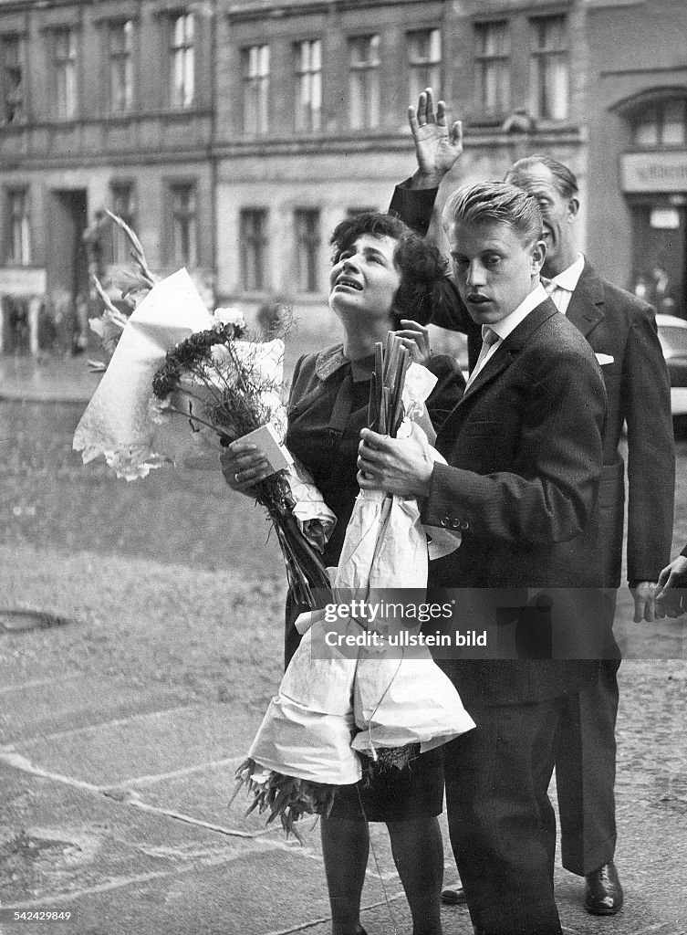 Germany / GDR, Berlin. Wedding scene at Bernauer Strasse. The wedding couple in West-Berlin standing at the border. They look to the window of the house of the parents of the bride, which is in East-Berlin. On picture no. 00338156 you will see the sc