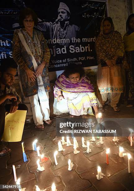 Pakistani activists light candles in Karachi, on June 23, 2016 as thousands of Pakistani thronged the streets of Karachi to attend the funeral of one...