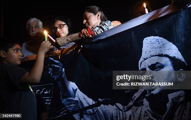 Pakistani activists light candles in Karachi, on June 23, 2016 as thousands of Pakistani thronged the streets of Karachi to attend the funeral of one...