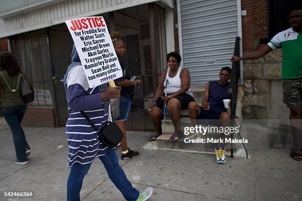 Woman holds a sign seeking justice for black men killed by police officers after Baltimore police officer Caesar Goodson Jr. Was found not guilty on...