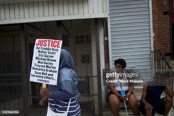 Woman holds a sign seeking justice for black men killed by police officers after Baltimore police officer Caesar Goodson Jr. Was found not guilty on...
