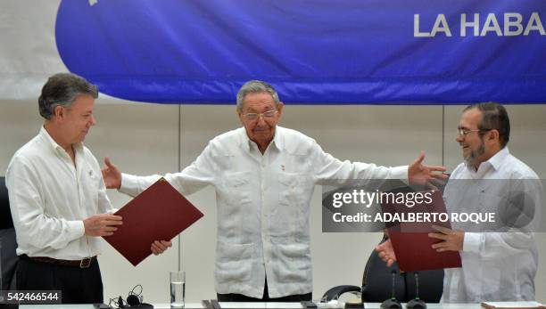Colombia's President Juan Manuel Santos and Timoleon Jimenez, aka "Timochenko" , head of the FARC leftist guerrilla, hold folders with documents as...