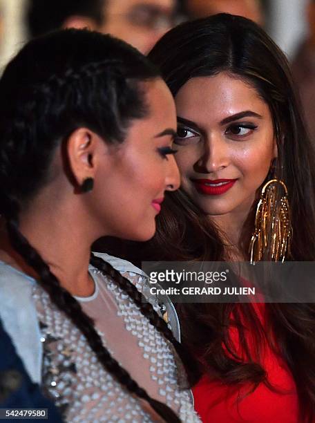 Indians actresses Sonakshi Sinha and Deepika Padukone chat during the press conference for the 17th edition of IIFA Awards in Madrid on June 23,...
