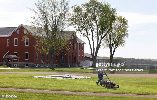 Dave Dwinal, of the Southern Maine Community College grounds crew, mows the infield of the baseball diamond Wednesday, May 20, 2015 in South...