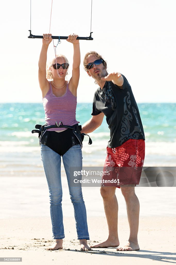 France, Bretagne, Finistere, teacher explaning girl how to use kite