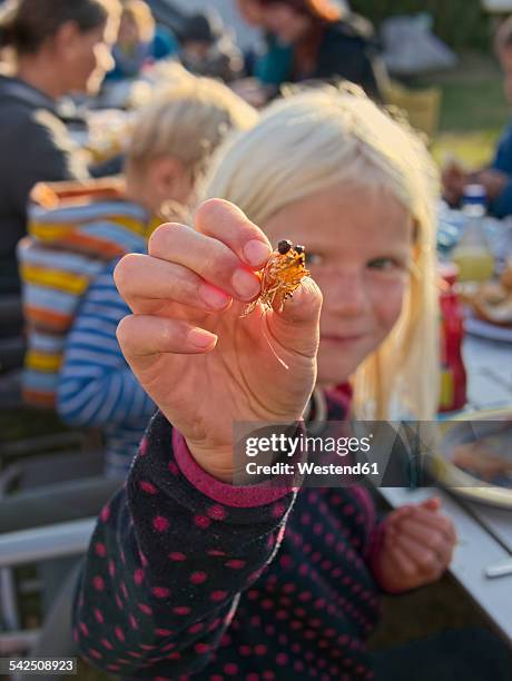 Girl holding shrimps at a barbecue on a camping ground