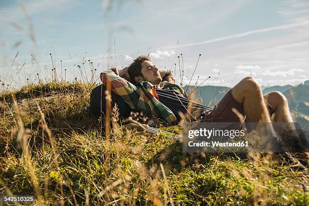 austria, tyrol, tannheimer tal, young hiker having a rest - oostenrijk stockfoto's en -beelden