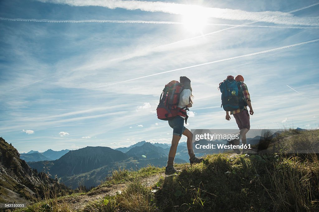 Austria, Tyrol, Tannheimer Tal, young couple hiking on mountain trail