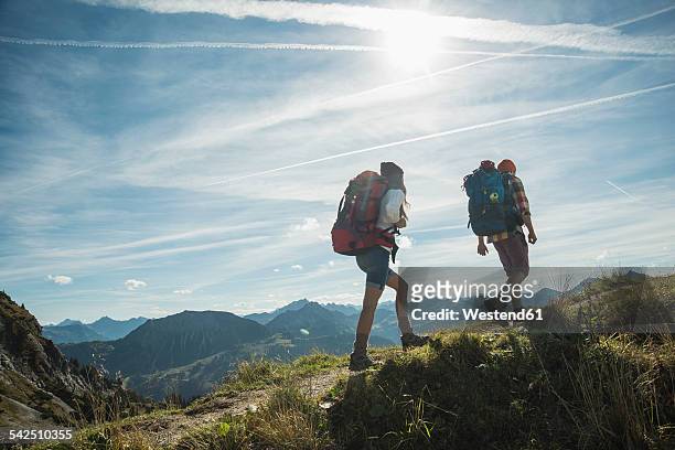 austria, tyrol, tannheimer tal, young couple hiking on mountain trail - tyrol austria stock pictures, royalty-free photos & images