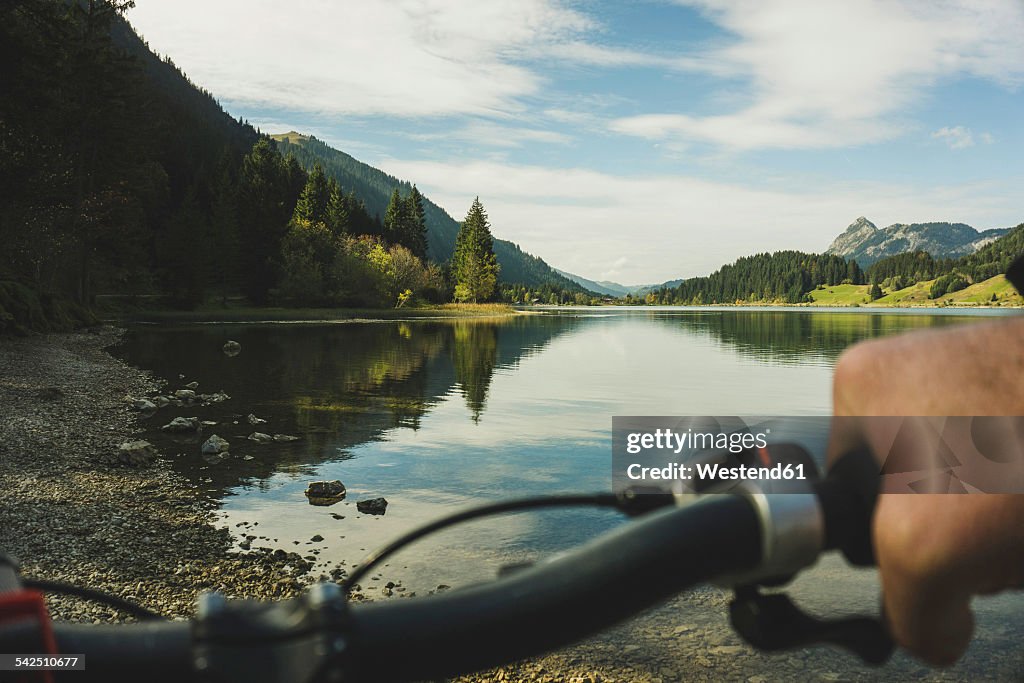 Austria, Tyrol, Tannheimer Tal, man on mountainbike at lakeshore